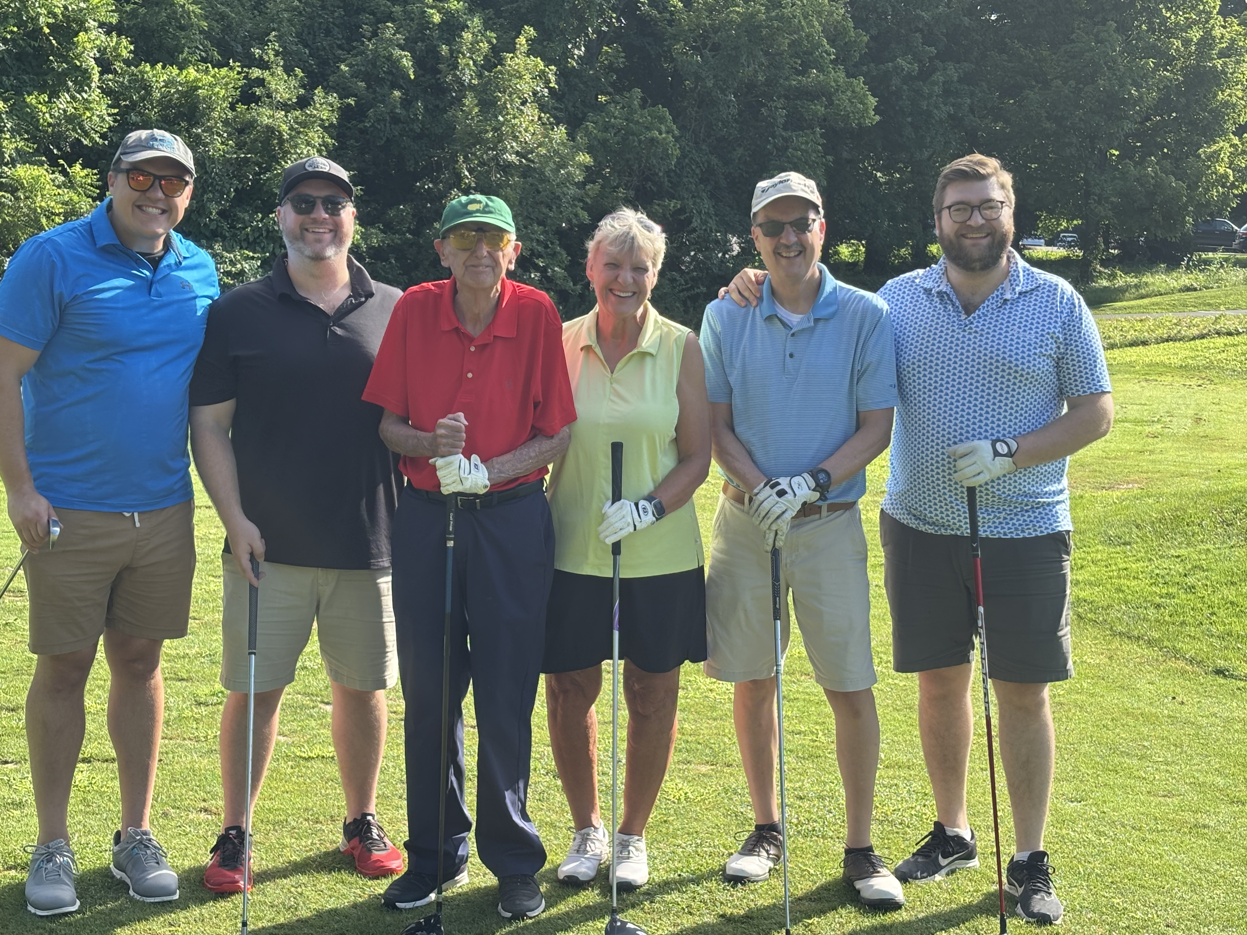 John Angerer surrounded by friends and family on the golf course.