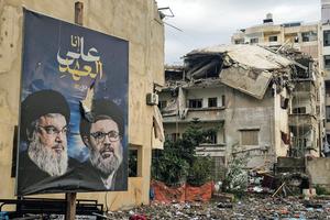 A photograph shows a banner bearing portraits the slain leaders of the Lebanese Shia movement Hezbollah, Hassan Nasrallah (l) and Hashem Safieddine, at the site of an overnight Israeli airstrike that targeted the Burj al-Barajneh neighborhood in Beirut's southern suburbs on March 14. Lebanon was drawn into the Middle East war last week when Iran-backed militant group Hezbollah attacked Israel in response to the killing of the Iranian supreme leader during US-Israeli strikes.
