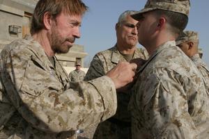 Actor Chuck Norris (left) visits the United Service Organizations (USO) Camp Taqaddum in the Al Anbar province of Iraq in November 2006. 