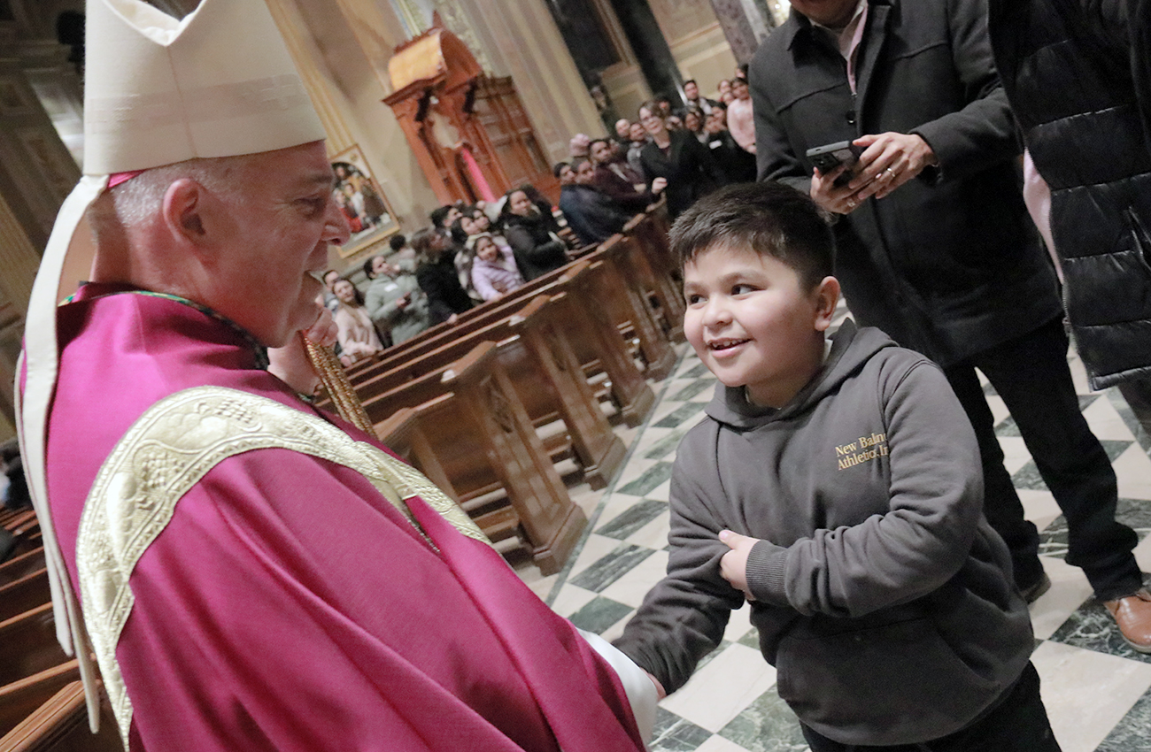 Archbishop Nelson Pérez greets a young catechumen during the Rite of Election liturgies on Feb. 21-22 at the Cathedral Basilica of Saints Peter and Paul in Philadelphia, Pa.