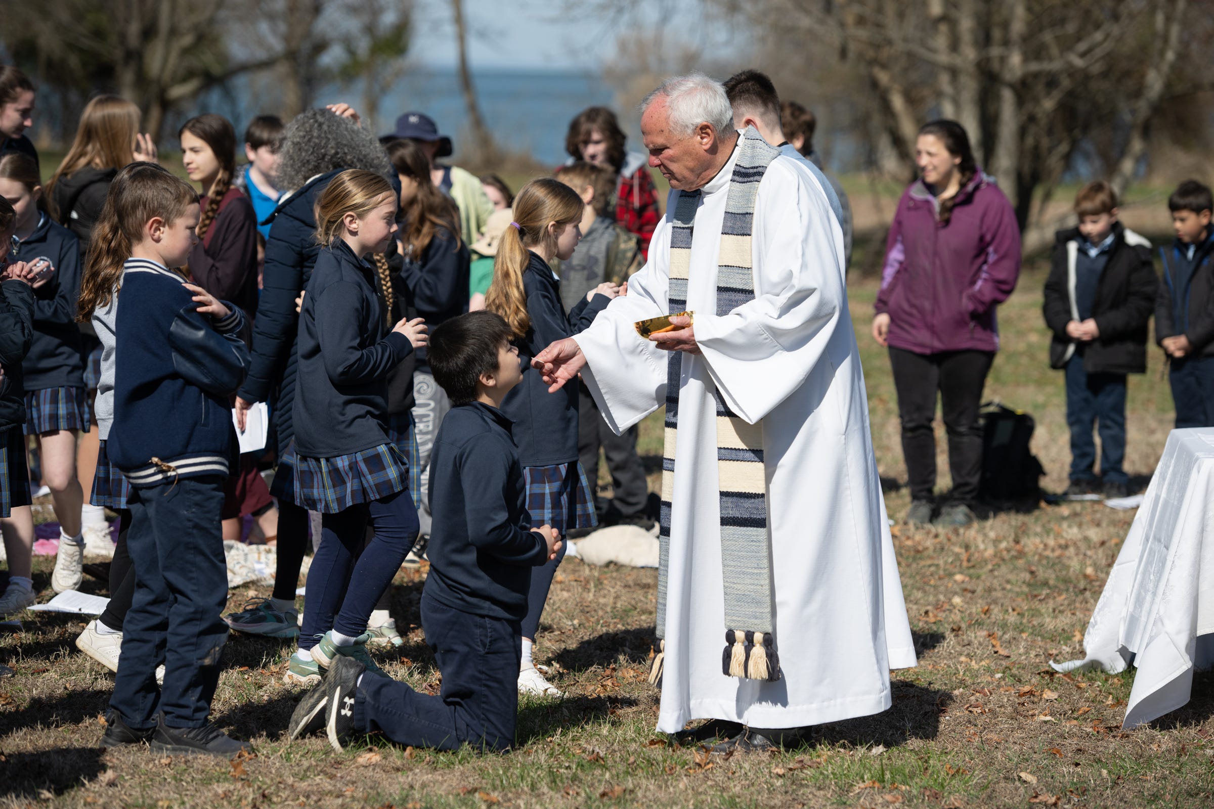 Fr. Mark Horak S.J. distributes Holy Communion to the students of Fr. Andrew White Elementary School.