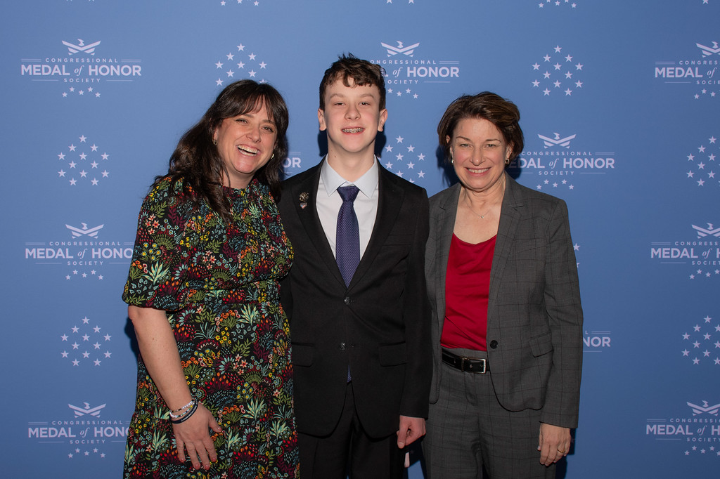 (L-R) Annie Greenawalt stands next to her son and Senator Amy Klobuchar on March 25, 2026 during the Medal of Honor ceremony in Washington, D.C. 