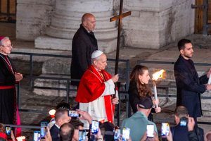 Pope Leo XIV carries the cross during the Via Crucis at the Colosseum in Rome, Friday, April 3, 2026.