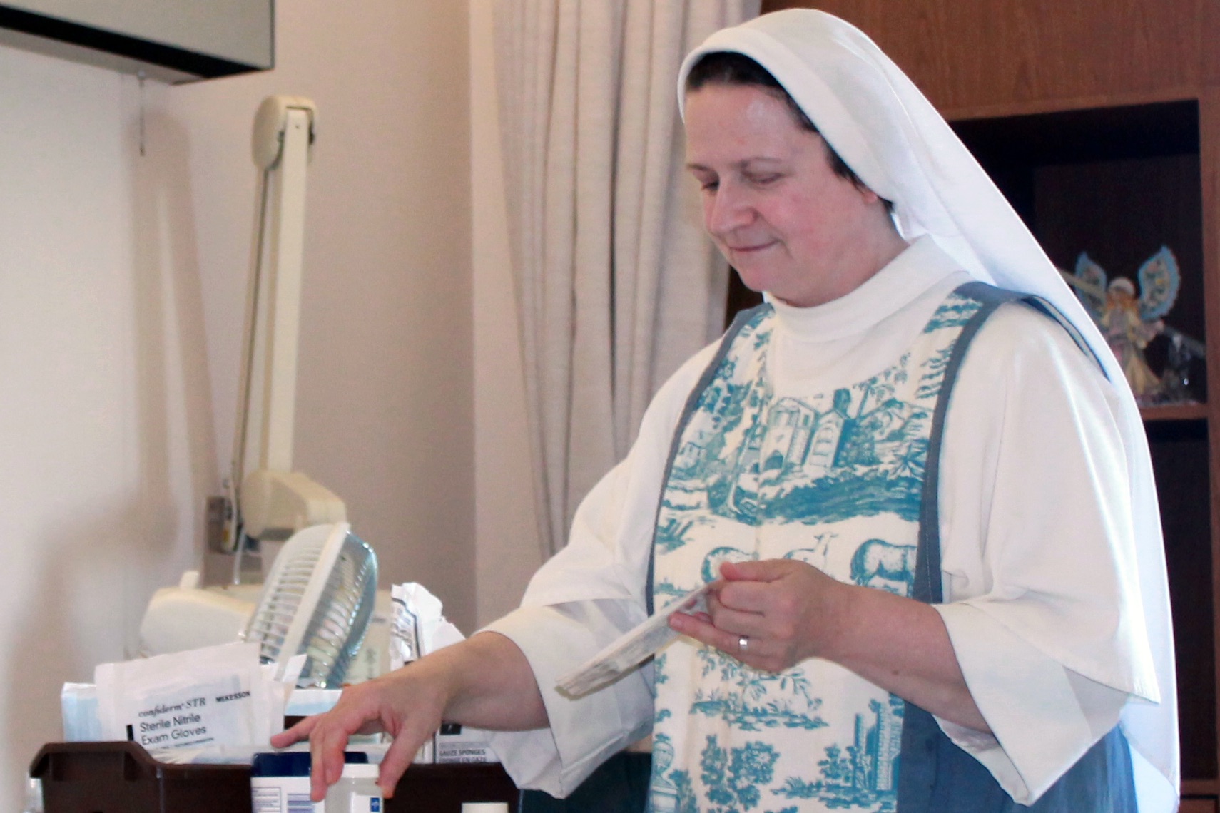 Dominican Sister in white habit tending to an elderly cancer patient at Rosary Hill Home hospice in Hawthorne New York