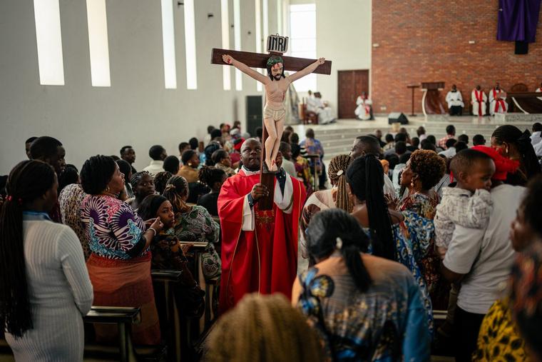 A priest carries the crucifix past Catholic worshippers during a Good Friday service at the Bienheureuse Anuarite parish during Holy Week, ahead of Easter, in Goma, Democratic Republic of the Congo, on April 3, 2026. 