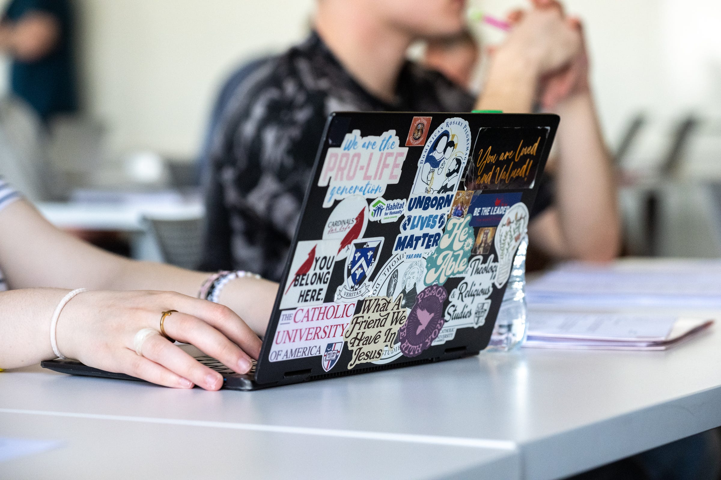 A student's laptop adorned with pro-life stickers during class at CUA. 