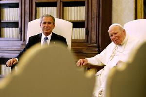 US President George W. Bush smiles during his meeting with Pope John Paul II in the Clementine Hall at the Vatican, Friday, June 4, 2004. In March 2003, John Paul II spoke publicly and repeatedly against President Bush’s plans to invade Iraq.