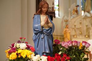 A statue of the Blessed Mother is surrounded by flowers in Immaculate Conception Cathedral in Brownsville, Texas.