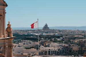 The Maltese flag flies high, overlooking the island of Gozo.