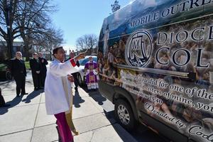 Bishop Earl Fernandes of the Diocese of Columbus, Ohio, blesses the new mobile outreach ministry van outside of the Basilica of St. Mary of the Assumption on Sunday, March 8 in Lancaster, Ohio. 
