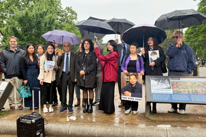 Grace Jin Drexel (in red raincoat) holds an umbrella in a photo with fellow religious-freedom advocates at a rally in front of the White House on May 11, 2026, in Washington, D.C. 