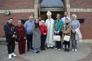 Jesuit Bishop Alan McGuckian stands after Mass on May 3, 2026, at Corpus Christi chapel with relatives of the Springhill/Westrock shooting victims. 