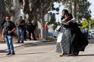 Two women react as they leave a reunification center following the shooting at the Islamic Center of San Diego in southern California, May 18, 2026. A shooting at the largest mosque complex in San Diego killed three people, with two suspected teenage gunmen later found dead in a car from self-inflicted gunshot wounds, police said.