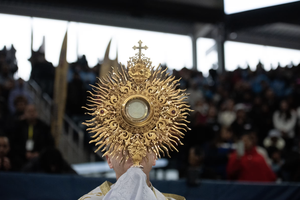 Bishop Robert Brennan carries the Blessed Sacrament during a Eucharistic procession at Louis Armstrong Stadium on April 20, 2024. 