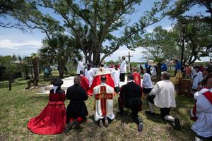 Beneath the trees at the Rustic Altar, Bishop Erik Pohlmeier and pilgrims kneel before the Blessed Sacrament…the still center of a journey about to move through the nation.