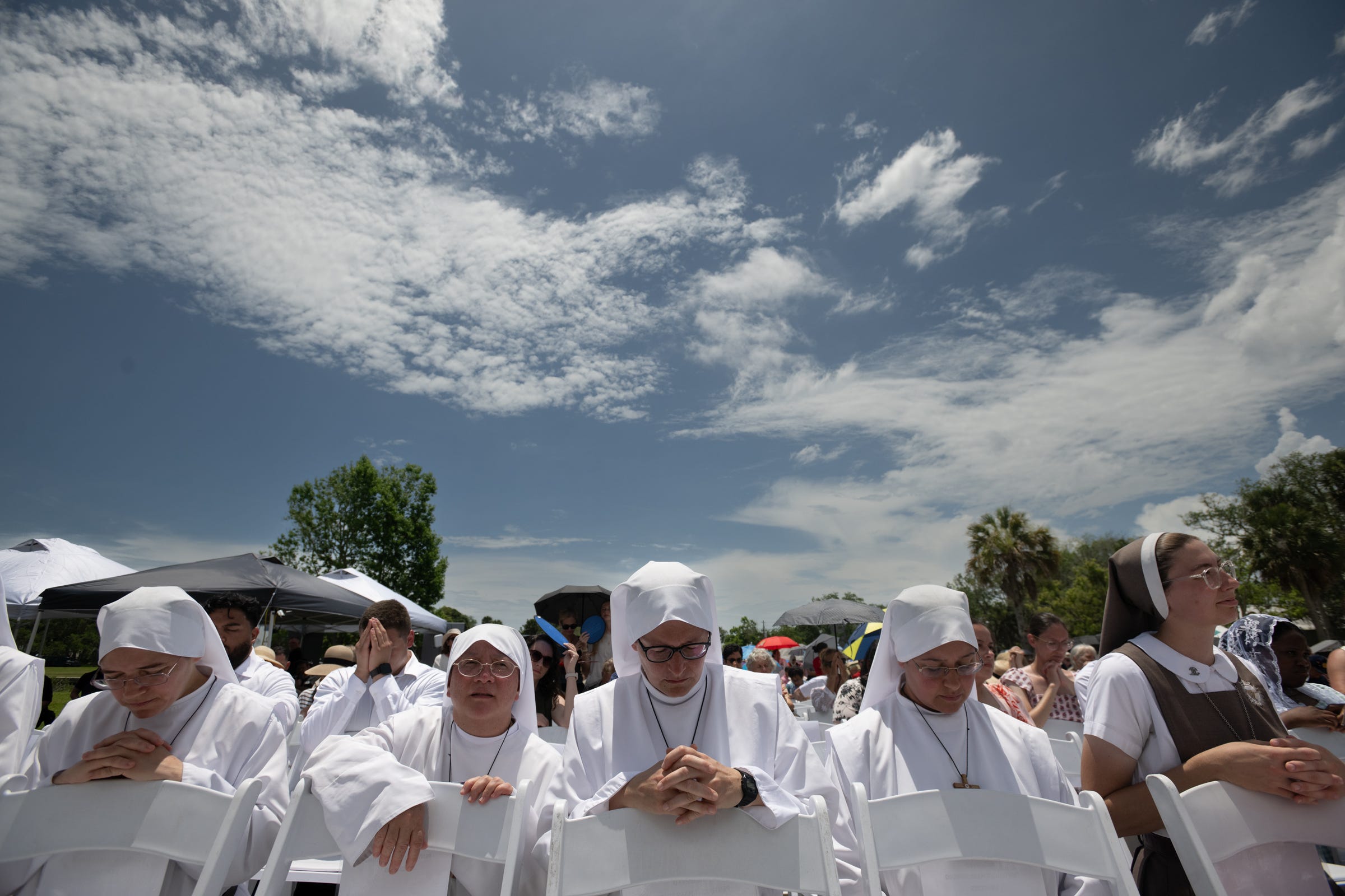 Religious sisters kneel in prayer during Mass. 