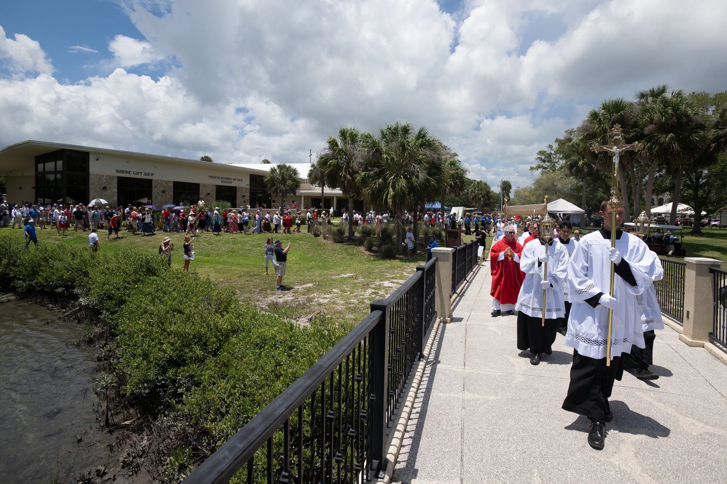 Following the opening Mass at Mission Nombre de Dios, the Eucharistic procession moves past tidal waters and palms at the National Shrine of Our Lady of La Leche, carrying Christ deeper into the oldest Catholic city in the United States.