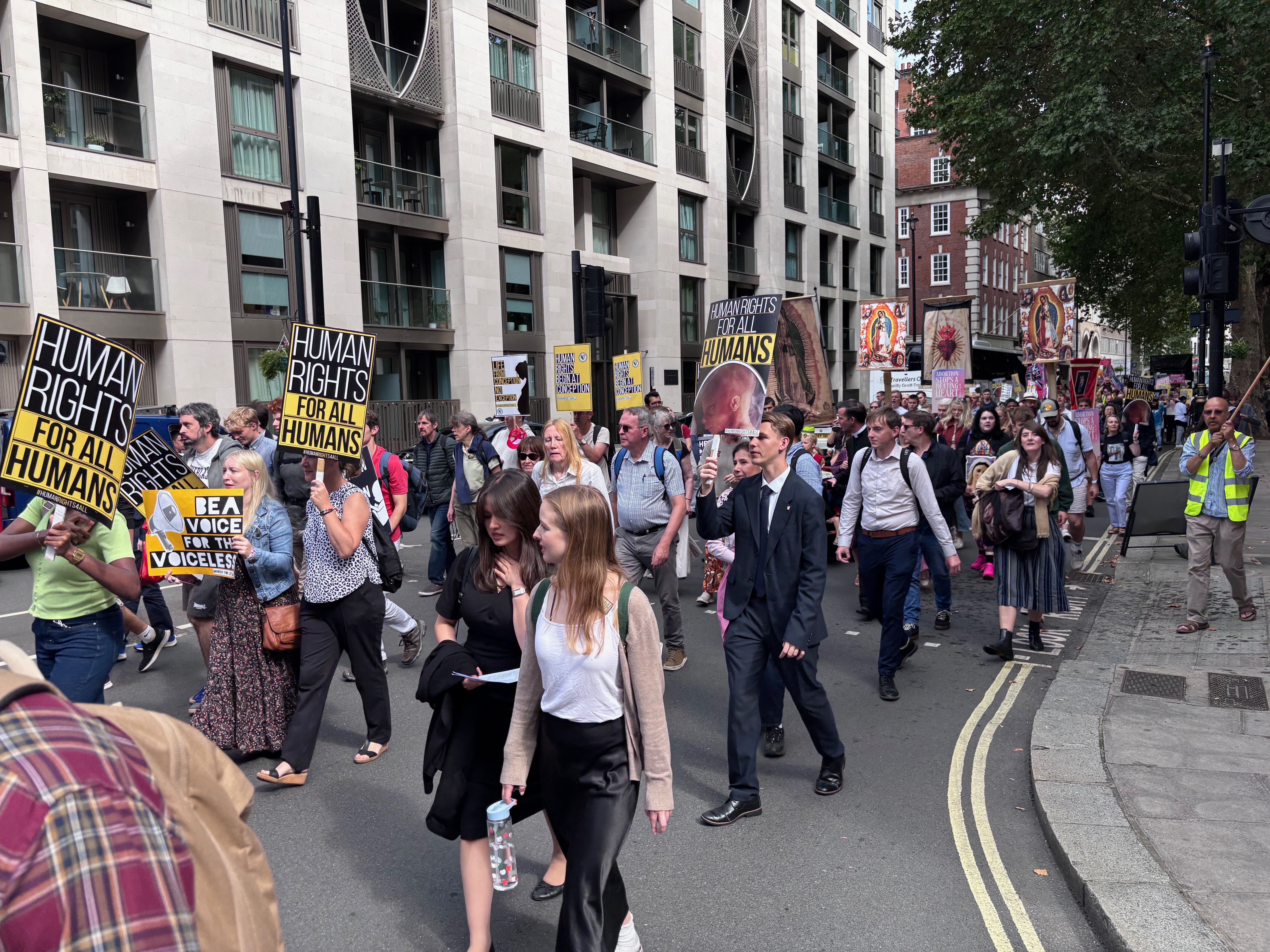 Crowds march holding signs during March for Life UK in 2025.