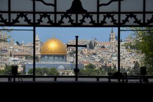 A view of the Dome of the Rock, from a window with cross ironwork, in Jerusalem.