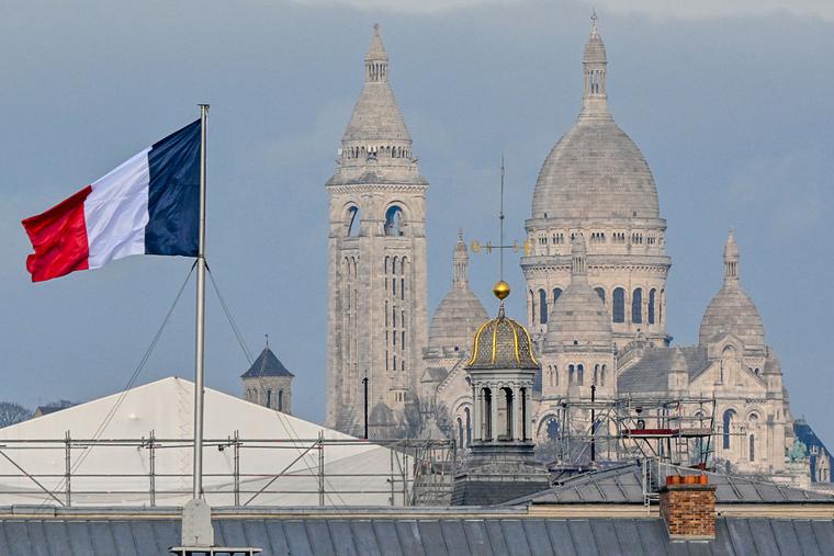 View of the Sacre-Coeur at Montmartre with a French flag in the foreground in the capital, Paris, France, on January 20 2026. 