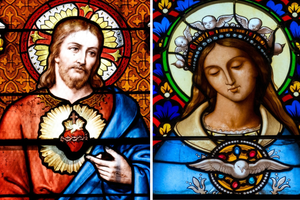 (L-R) Stained glass depictions of the Sacred Heart of Jesus and the Immaculate Heart of Mary.