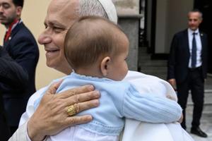 Pope Leo XIV embraces a baby during his apostolic journey to Spain.