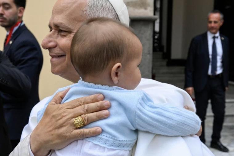 Pope Leo XIV embraces a baby during his apostolic journey to Spain.