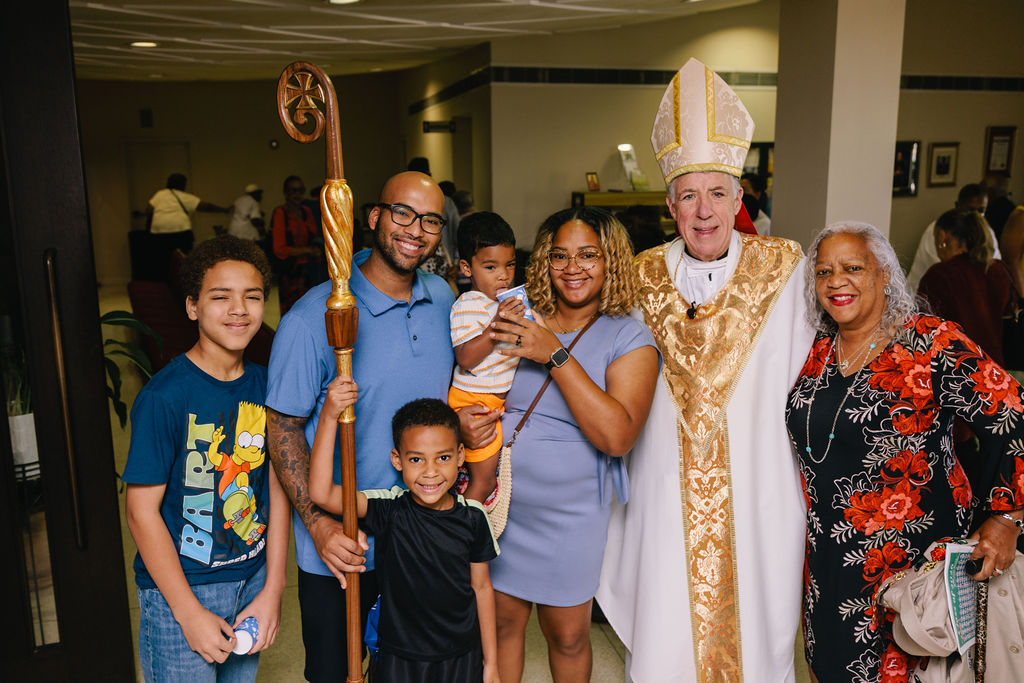 Archbishop James Checchio poses with a family after the Consecration to the Sacred Heart of Jesus at St. Louis Cathedral on June 14, 2026. 
