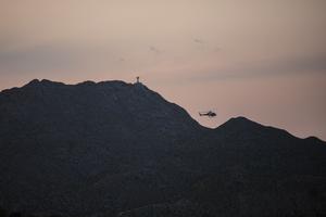 A U.S. Customs and Border Protection Helicopter is pictured patrolling the border at Mount Cristo Rey in Sunland Park, New Mexico, on July 22, 2021, with a statue of Christ just visible atop the mountain. The Diocese of Las Cruces is working to halt the federal government’s seizure of land at the base of the mountain.
