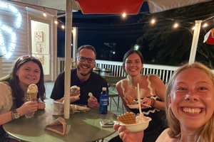 Father Michael Bremer enjoys ice cream with Lexie Hadjin (left) and other students from the UGA Catholic Center. 