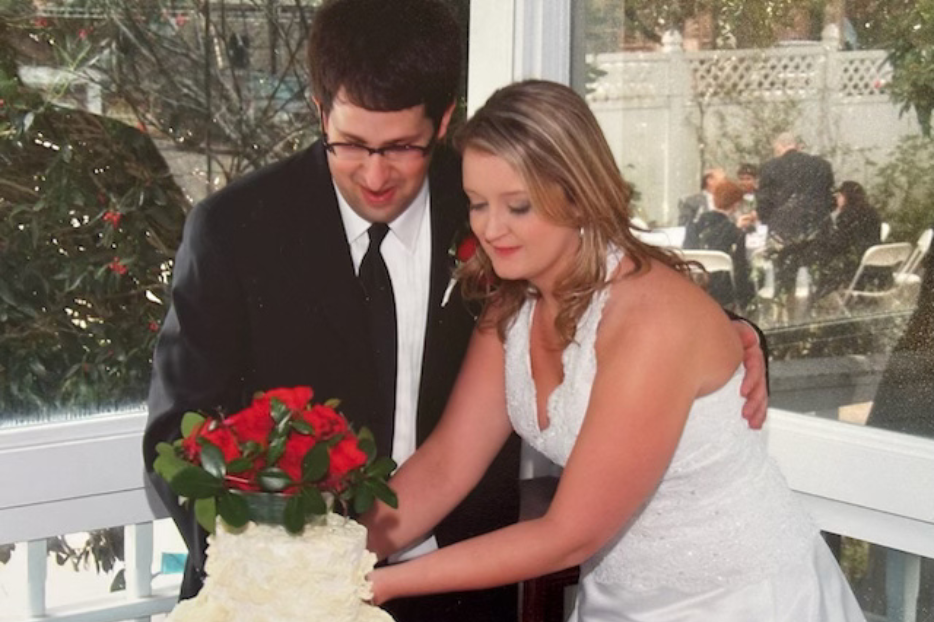 Mike and Jen Romano cut their wedding cake side by side during their wedding reception.