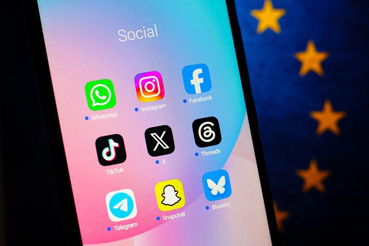 In this photo illustration, the WhatsApp, Instagram, Facebook, TikTok, X (Twitter), Threads, Telegram, Snapchat and Bluesky logos are seen displayed on a smartphone screen with the European Union flag in the background. June 21, 2026. 