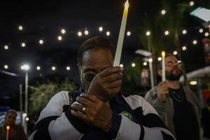 People pray during a candlelight vigil for Haitians living in the U.S. under the Temporary Protected Status (TPS) immigration program in Miami, Florida on Feb. 3, 2026.