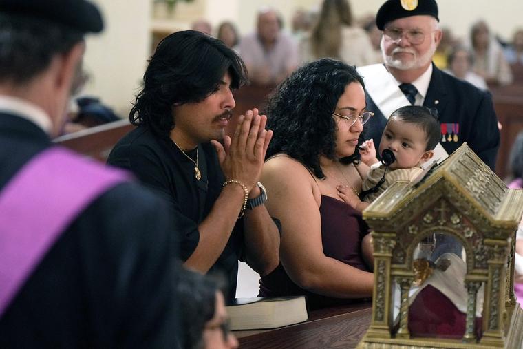 Javier and Melanie Carreno and their 1-year-old son, Uziel, venerate the major relics of St. Margaret Mary Alacoque at St. James Cathedral in Orlando, Florida, on June 12.