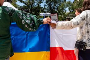 Ukrainian women hold Polish and Ukrainian flags in the Old Town of Krakow.