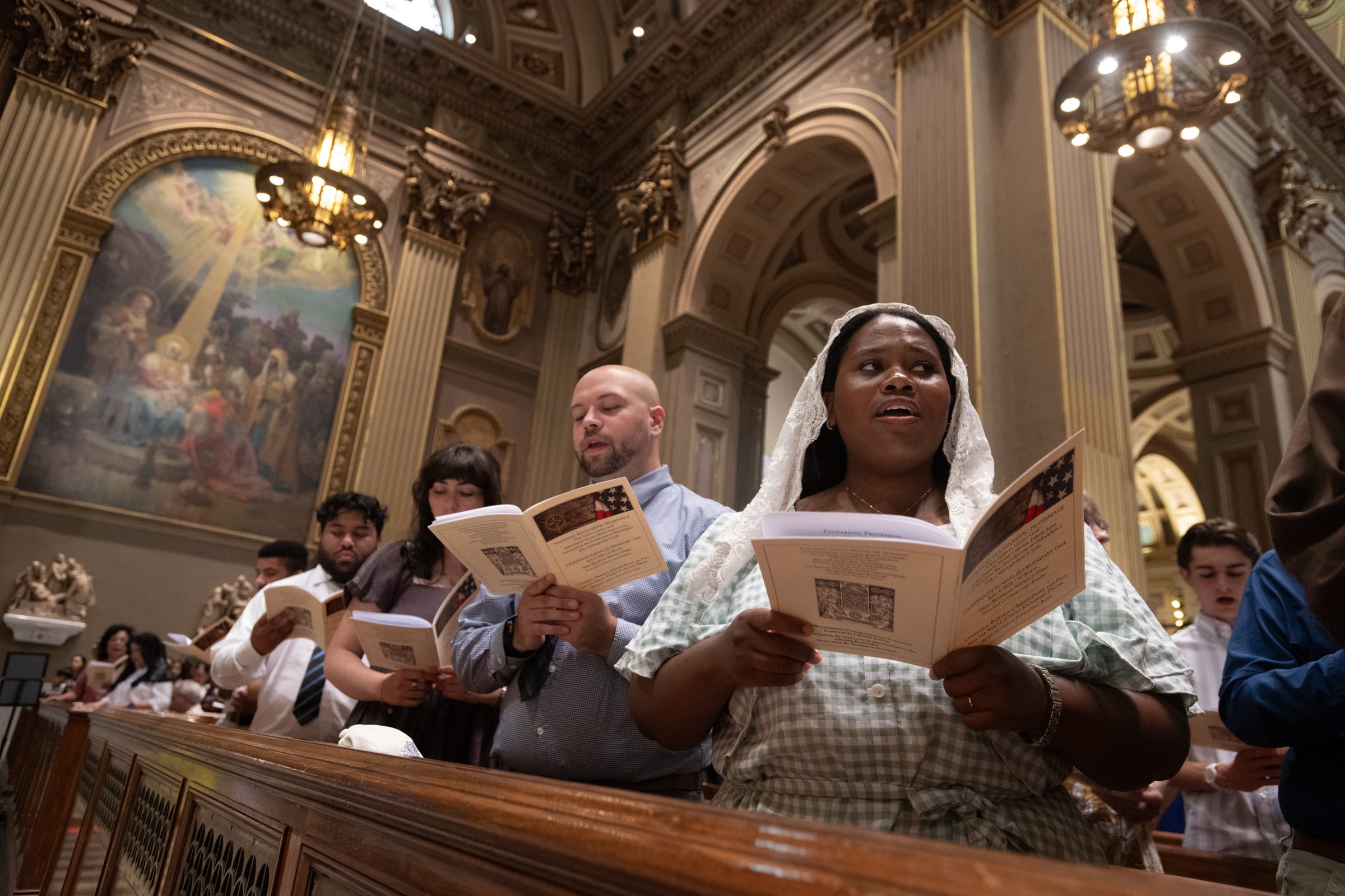 Pilgrims singing from printed programs, their voices rising in the timeless language of worship, with hearts and minds turned toward Christ.