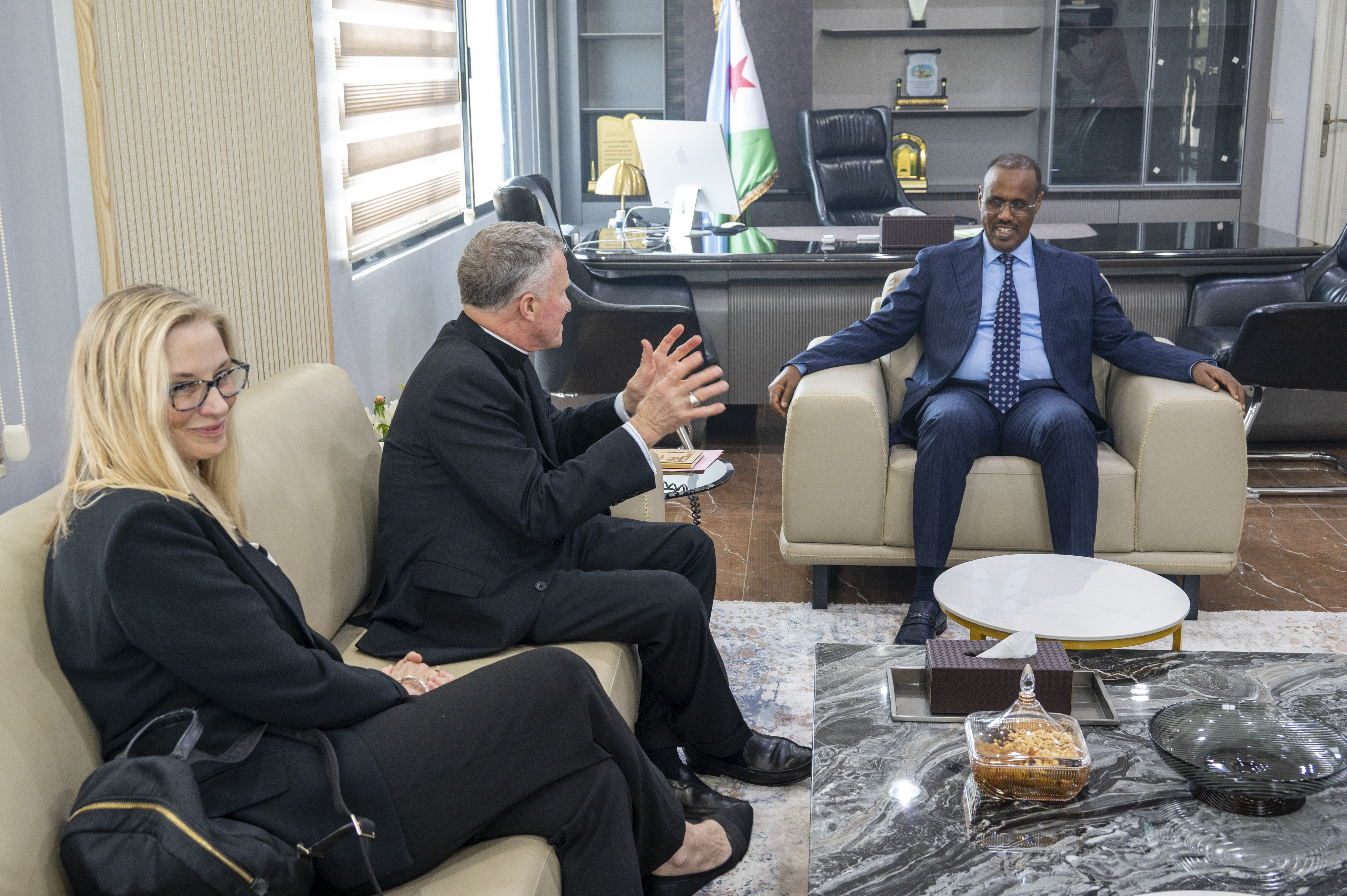 While traveling on pastoral visits to Catholic service members, the archbishop often meets U.S. diplomats and foreign officials. Here, in Djibouti, he sat down with the country’s Minister of Islamic Affairs, Moumin Hassan Barreh, accompanied by U.S. Ambassador Cynthia Kierscht. The two men conversed in French. Photo by Sgt 1st Class Kenneth Tucceri