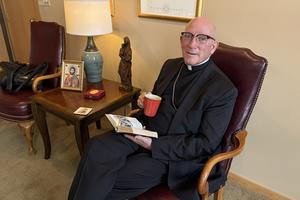 Bishop Edward Rice enjoys his coffee. 