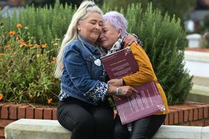 Mother and baby home survivors Mechelle Dillon, left, and Adele Johnstone comfort each other as the Truth Recovery Design Panel report findings into the mother and baby homes in Northern Ireland were released on Oct. 5, 2021, in Belfast, Northern Ireland. 