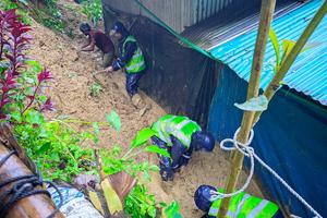 Caritas Bangladesh workers clear mud and debris beside shelters after a landslide at a Rohingya camp in Cox’s Bazar, Bangladesh, in July 2026.