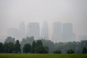 The skyline of downtown Minneapolis is shrouded in smoke on July 16, 2026. Smoke from wildfires in Minnesota and Canada is lowering air quality and visibility in the Minneapolis-St. Paul metro area.