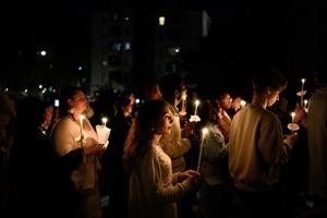 Christians enter a church, holding candles, to attend the Easter Vigil Mass on April 4, 2026, in Lyon.