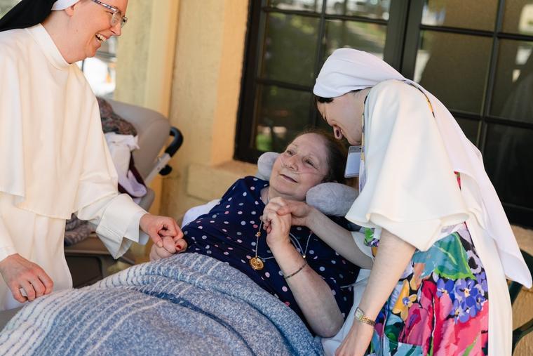 Dominican Sisters of Hawthorne serve a resident at Rosary Hill Home in New York, and the joy is evident.